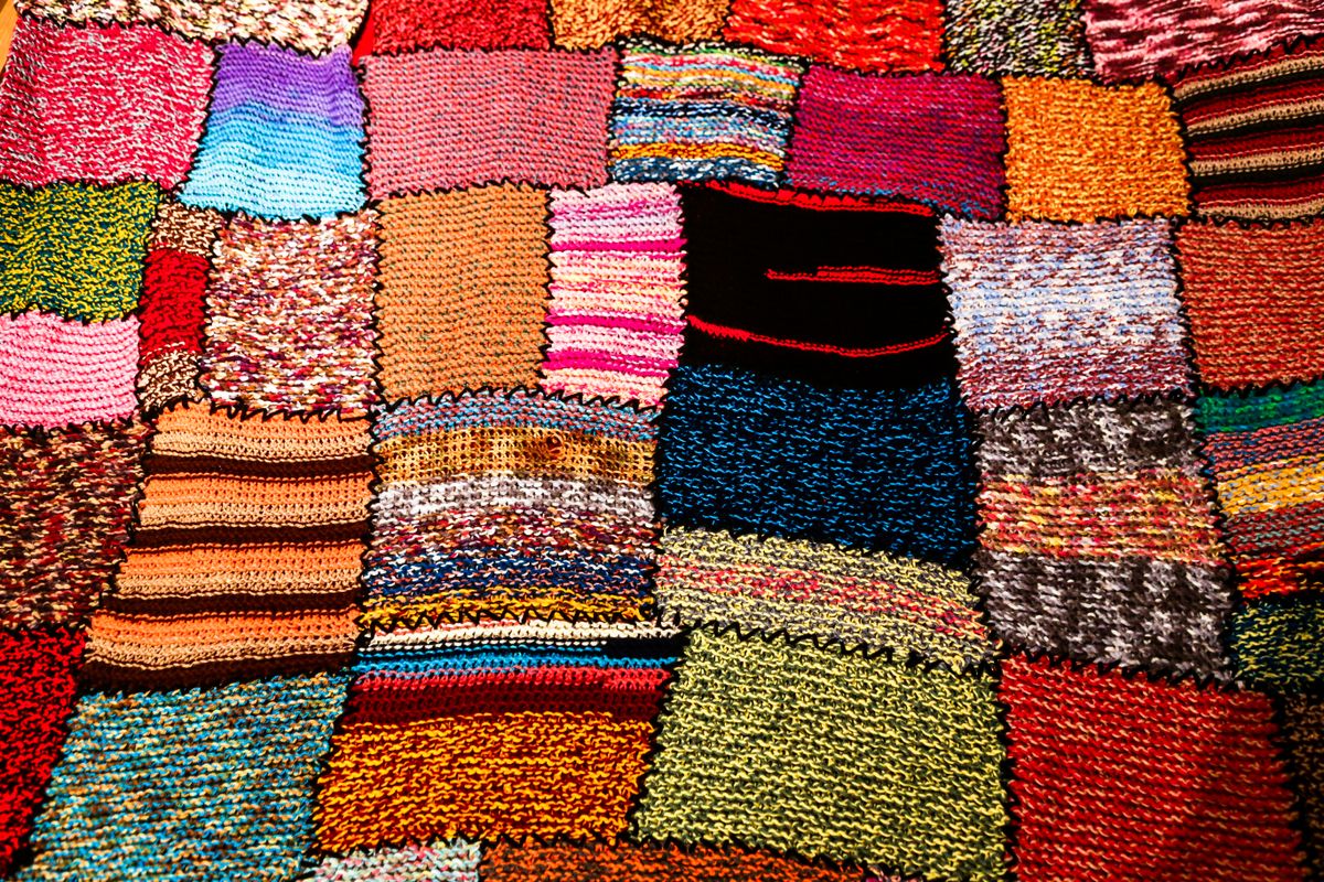A patchwork quilt with a wide range of differently sized and patterned squares and rectangles.