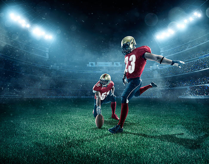 Two football players moments before a punt attempt.