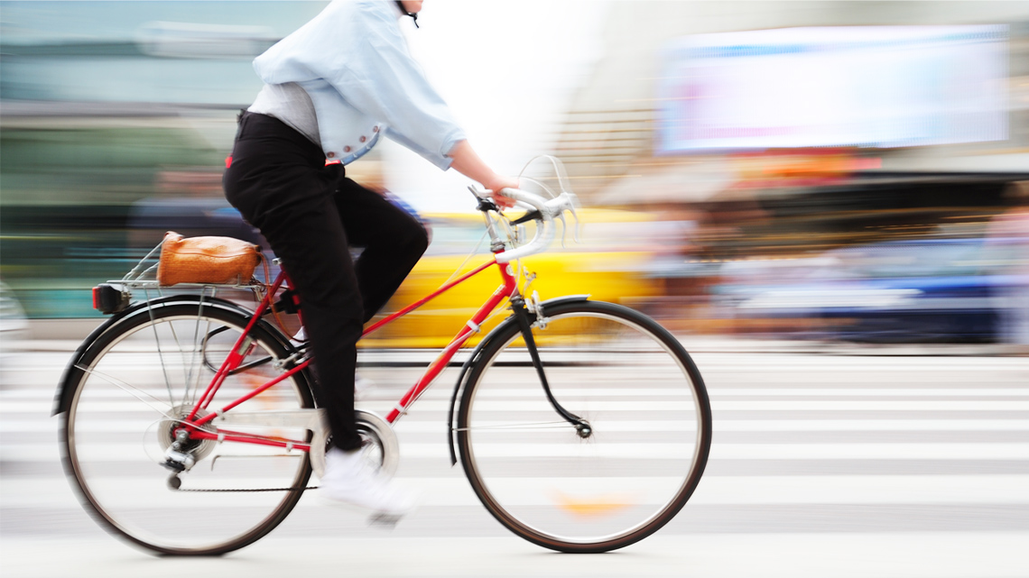 Person on a bicycle speeds through traffic on Stockholm’s Zebra Crossing.
