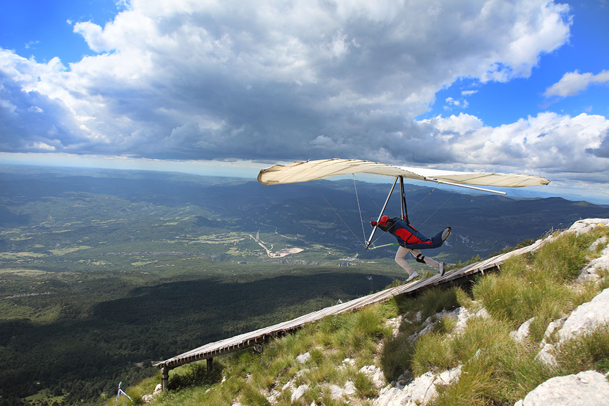 Person jumping off a cliff in a glider