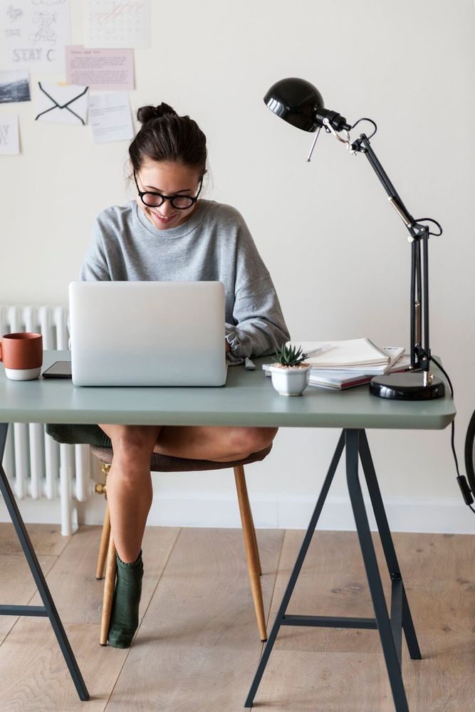 A young professional sits at a laptop during the day.